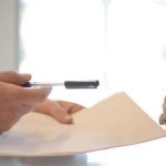 Insurance - Crop businessman giving contract to woman to sign
