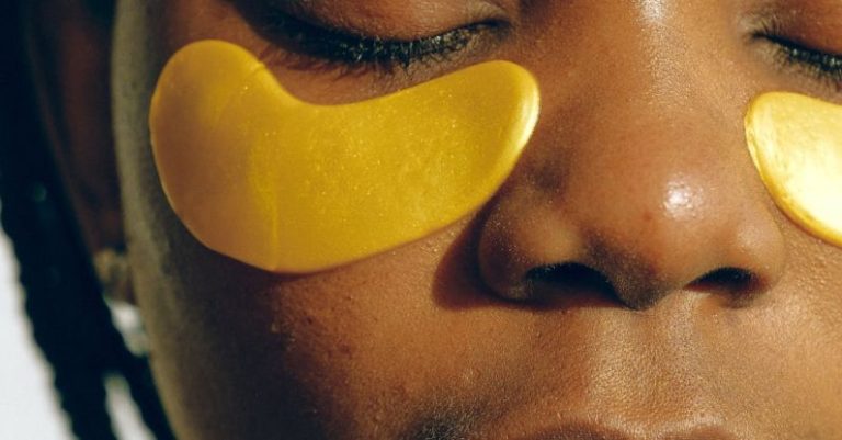 Salons - Crop gentle African American female with closed eyes and clean face enjoying cosmetic procedure for smoothing and moisturizing skin under eyes and removing dark circles