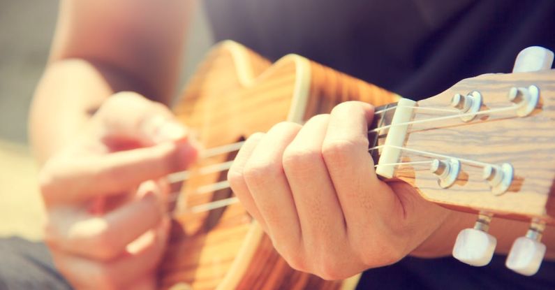 Hobby - Person Playing Brown Ukulele