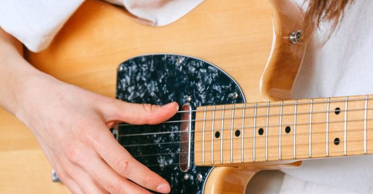 Hobbies - Woman in White Crew Neck T shirt Playing Brown and Black Electric Guitar