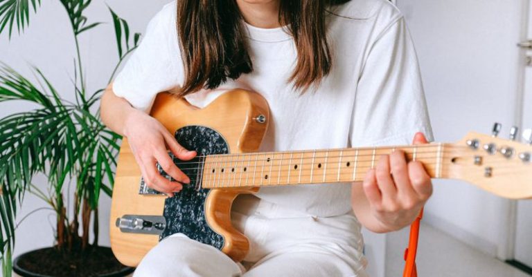 Hobbies - Woman In White Shirt Playing Brown Electric Guitar