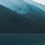 Travel Tips - Boat tip floating on rippling lake in mountainous terrain