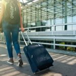 Travel - Woman Walking on Pathway While Strolling Luggage