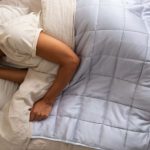Sleep Quality - A woman sleeping in a bed with a quilt