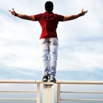 Independence - Person Raising Hands Mid-air Sidewards While Standing on Gray Steel Railings