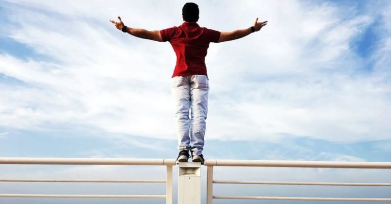 Independence - Person Raising Hands Mid-air Sidewards While Standing on Gray Steel Railings